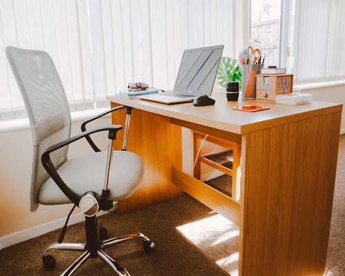 A tidy workspace arrangement with an ergonomic office chair and clear laptop posture setup